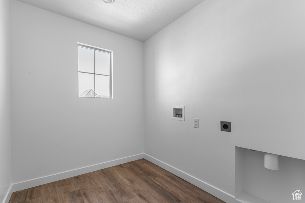 Washroom with dark wood-style flooring, baseboards, hookup for an electric dryer, hookup for a washing machine, and laundry area