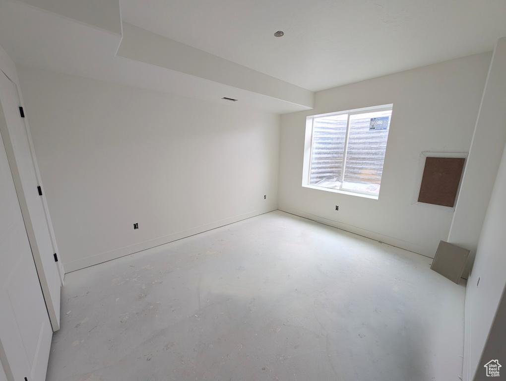 Unfurnished room with unfinished concrete flooring