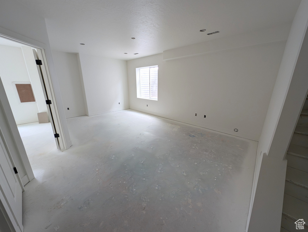 Empty room featuring unfinished concrete flooring