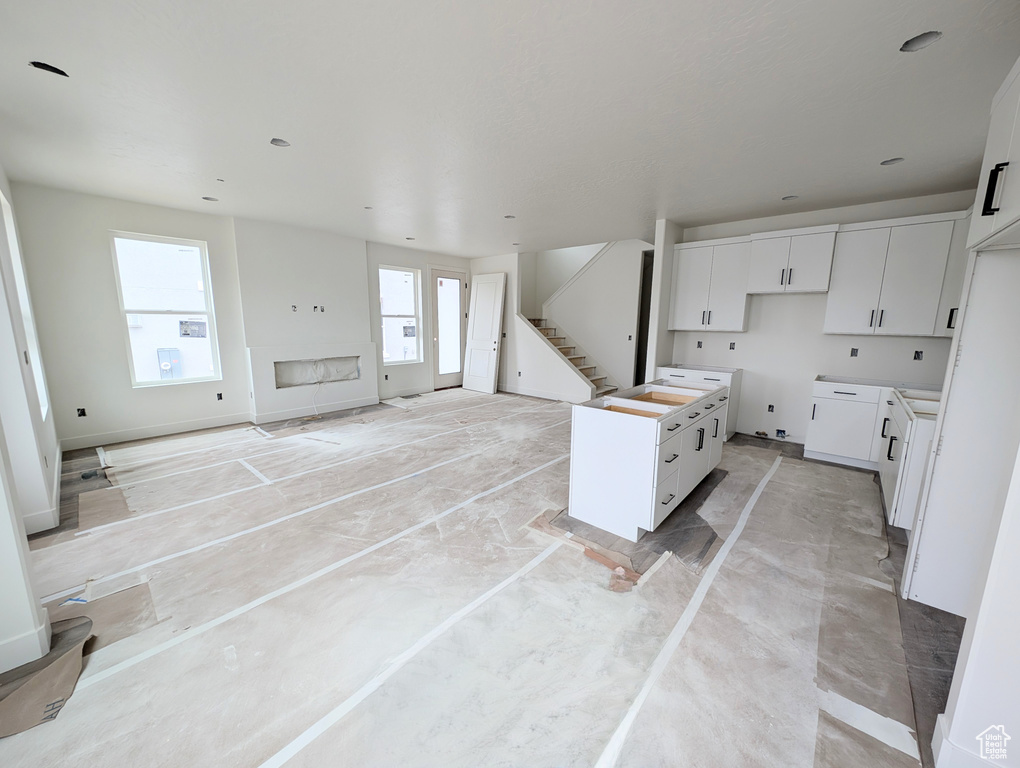 Kitchen with white cabinets, open floor plan, and a kitchen island