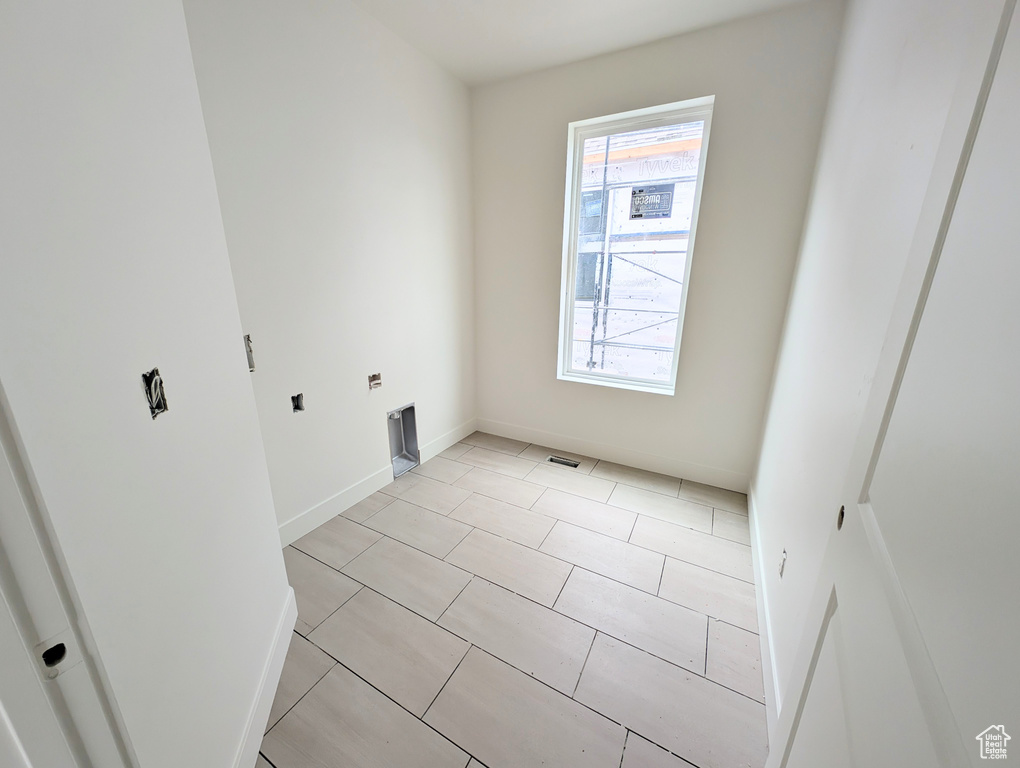 Spare room featuring baseboards and light tile patterned flooring