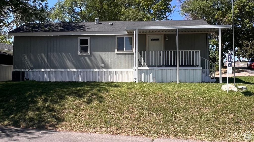 Manufactured / mobile home featuring covered porch and a front yard