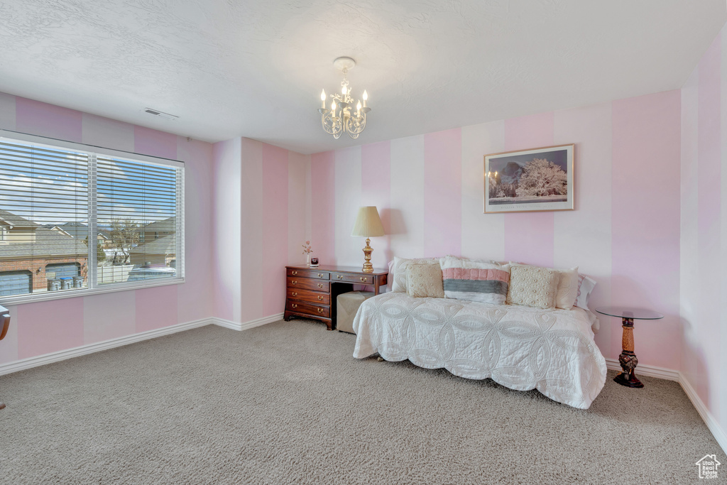 Carpeted bedroom featuring visible vents, baseboards, a notable chandelier, and a textured ceiling