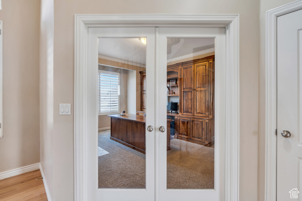 Interior space featuring carpet flooring, french doors, baseboards, and ornamental molding
