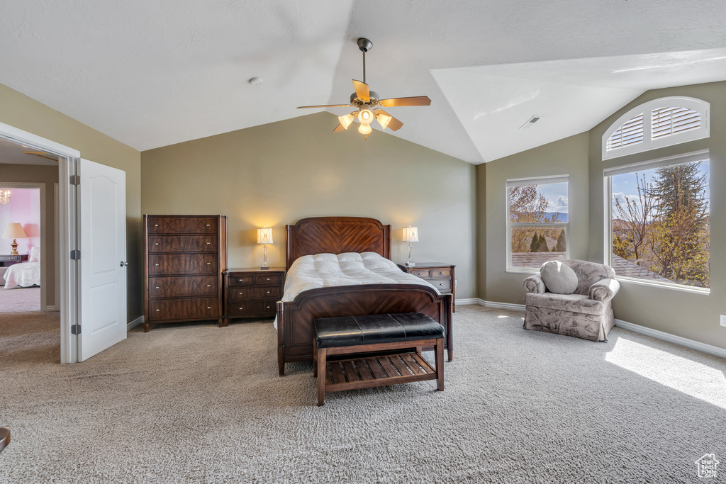 Carpeted bedroom with visible vents, ceiling fan, baseboards, and lofted ceiling