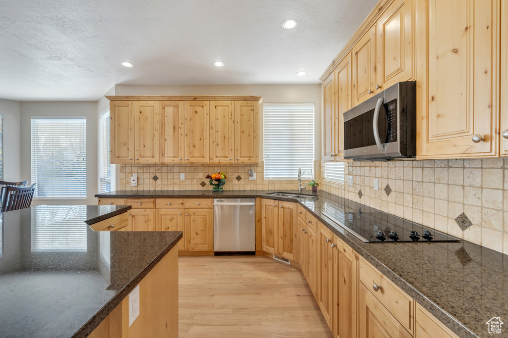 Kitchen featuring a sink, light wood-style floors, light brown cabinets, and stainless steel appliances