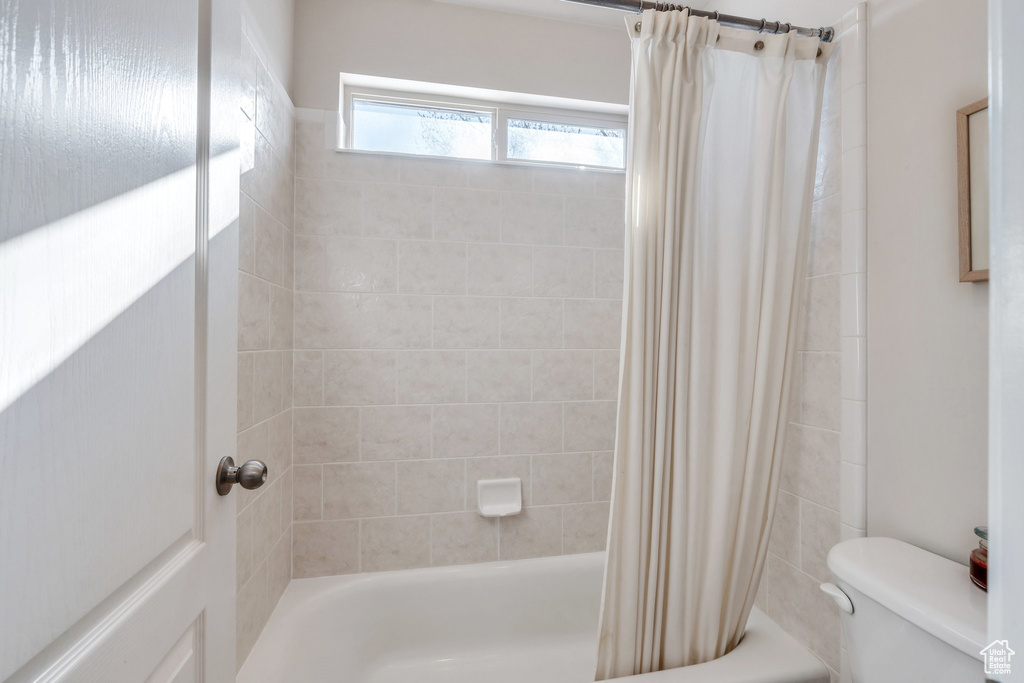Bathroom with shower / tub combo and toilet