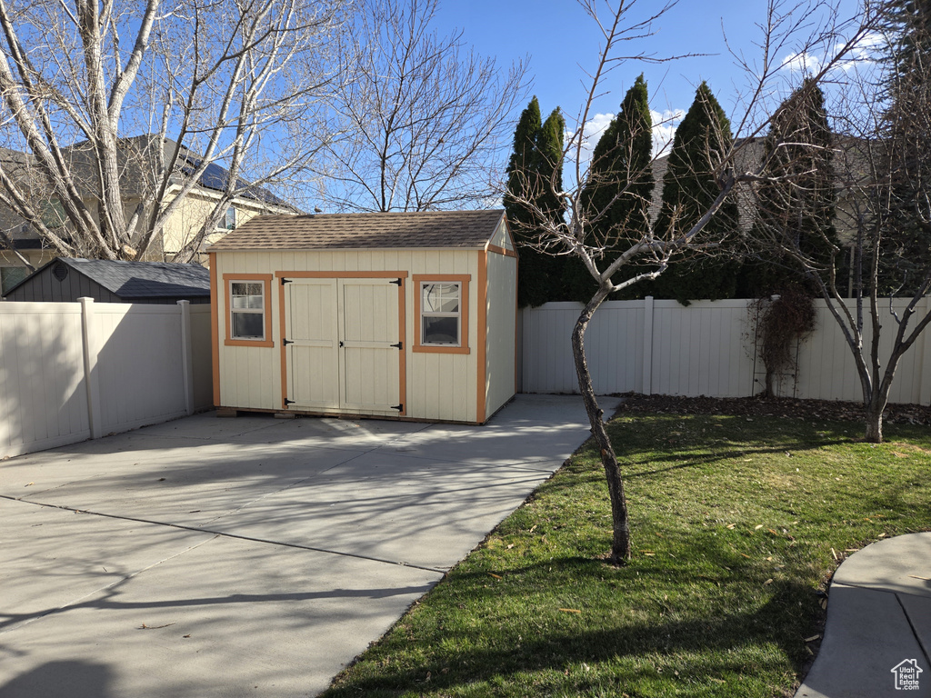 View of shed featuring a fenced backyard and concrete driveway