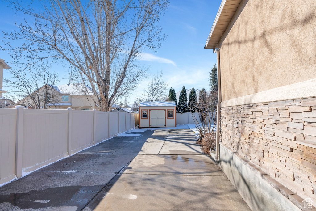 View of home\'s exterior featuring an outbuilding, a storage unit, stucco siding, and a fenced backyard
