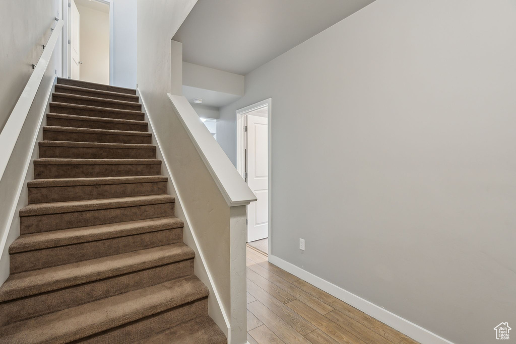 Stairway featuring baseboards and wood finished floors