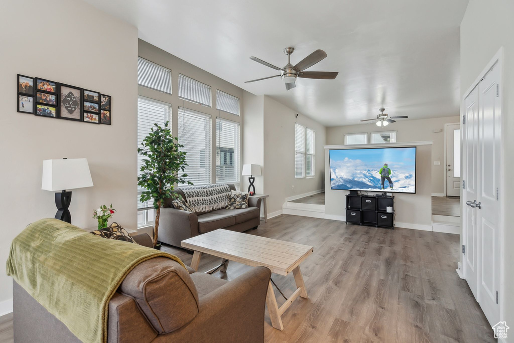 Living area featuring baseboards, wood finished floors, and a ceiling fan