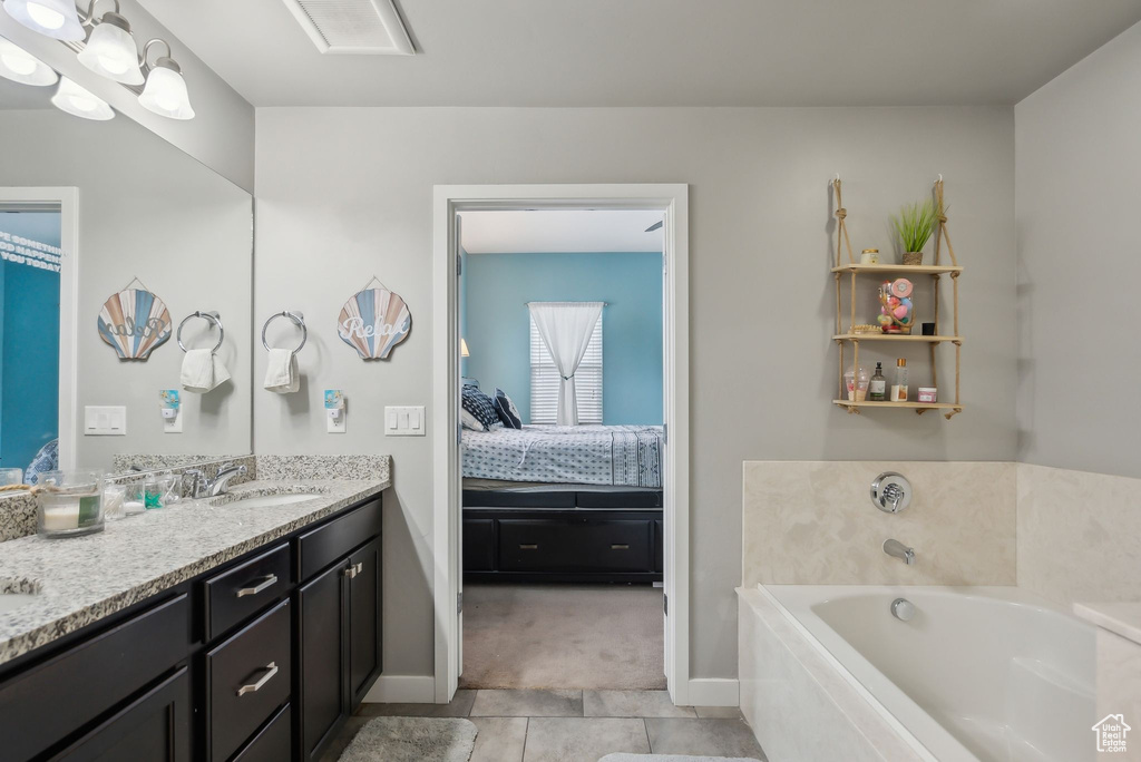 Full bath with a garden tub, ensuite bathroom, tile patterned flooring, baseboards, and vanity