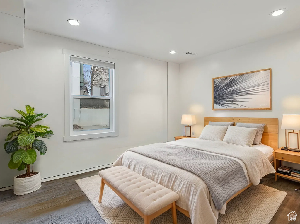 Bedroom featuring dark wood-type flooring, recessed lighting, and a baseboard radiator