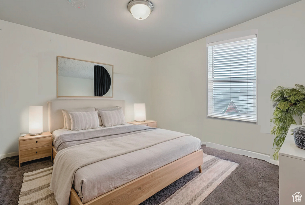 Bedroom with baseboards, carpet flooring, and vaulted ceiling