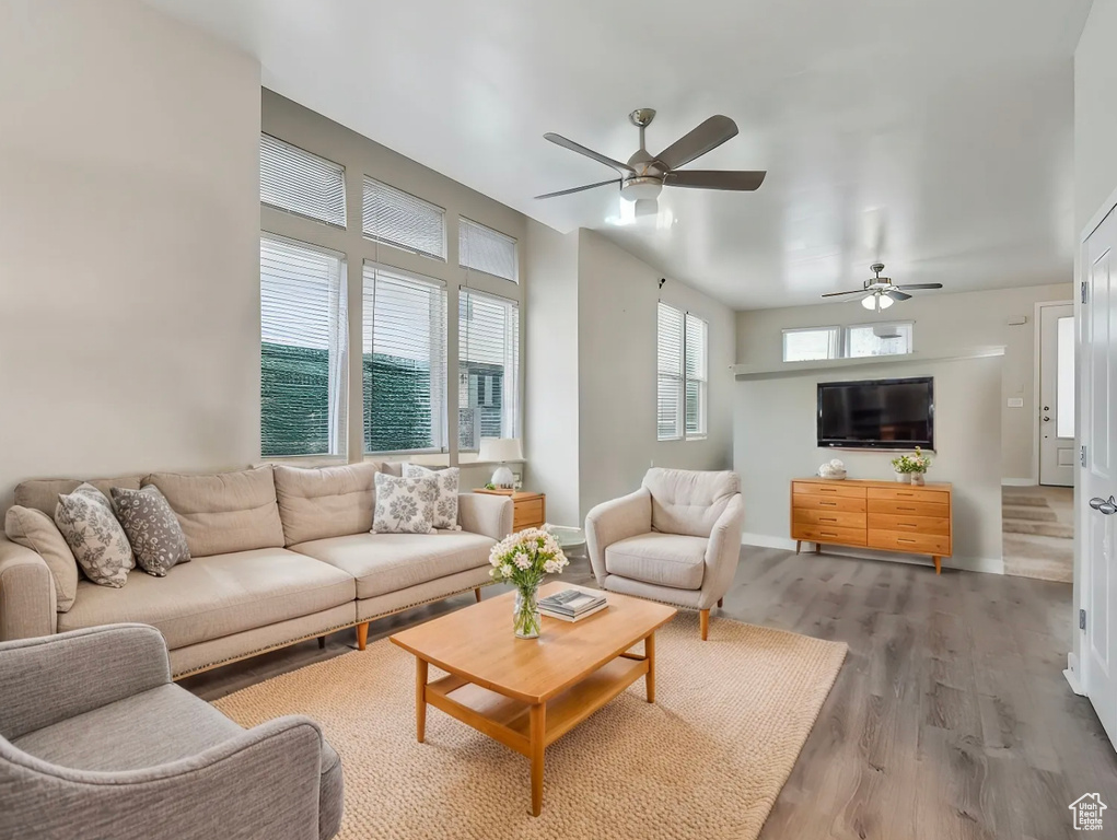 Living area featuring baseboards, ceiling fan, and wood finished floors