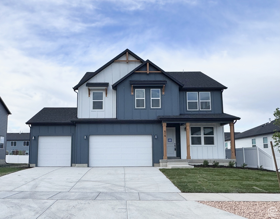 Modern inspired farmhouse with board and batten siding, concrete driveway, and a shingled roof