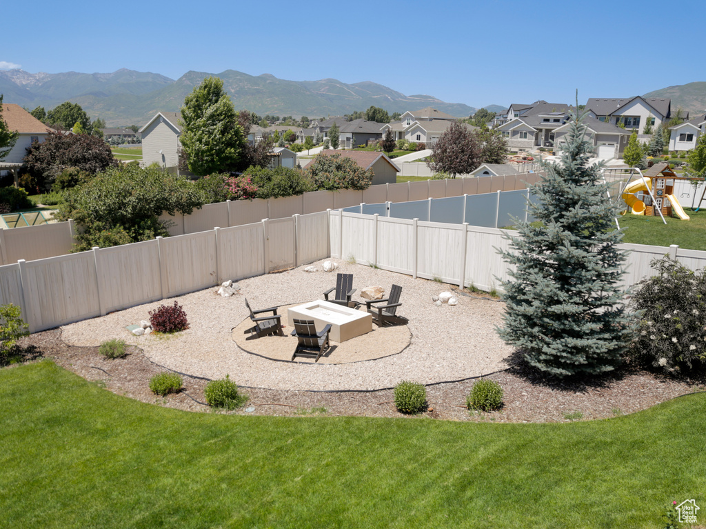 Fenced backyard featuring a residential view, a patio area, a mountain view, and a playground