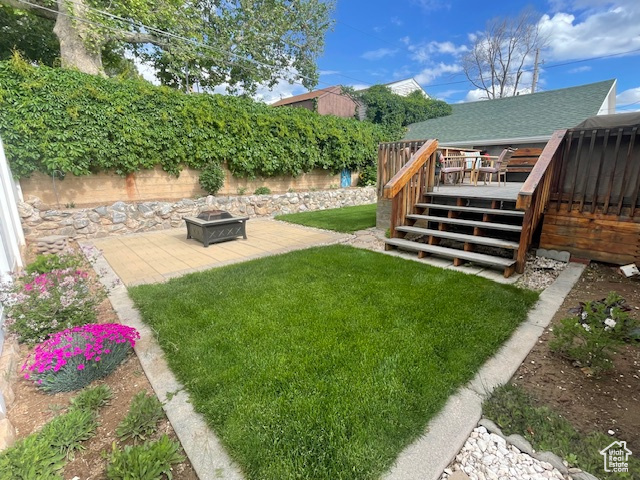 View of yard featuring a fire pit, a deck, a patio area, and stairs
