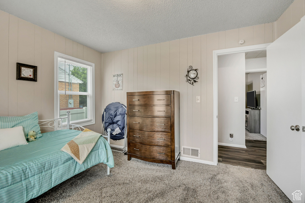Bedroom with a textured ceiling and carpet floors