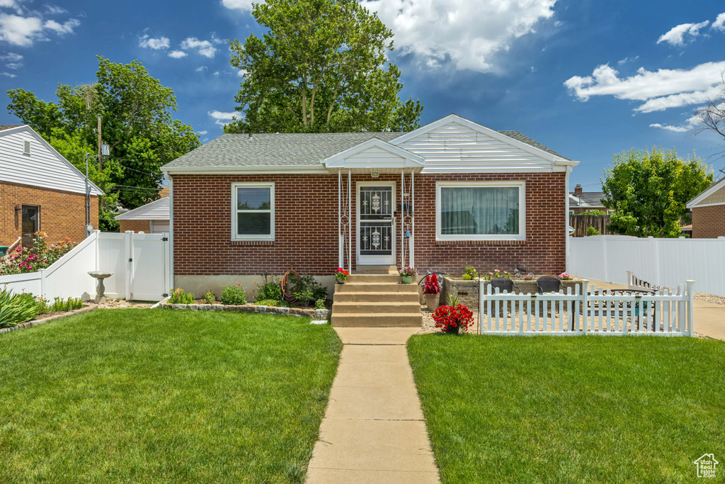 Bungalow-style home featuring brick siding, a fenced backyard, and a gate