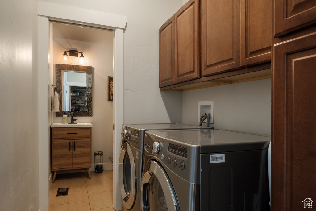 Washroom with washing machine and dryer, cabinet space, and baseboards