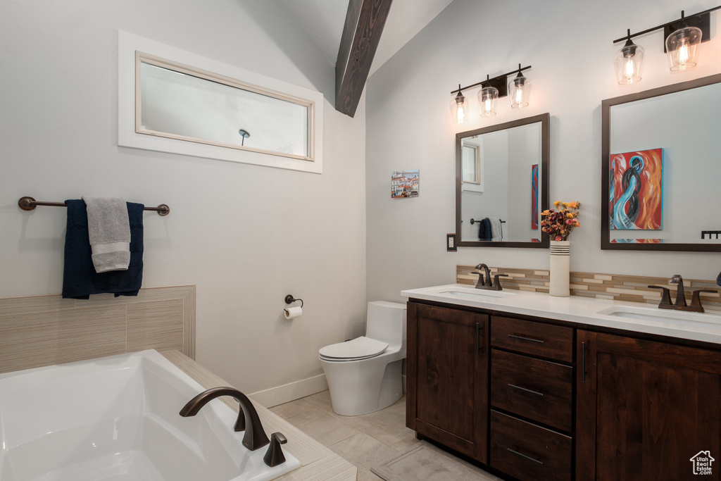 Full bathroom with double vanity, a bath, lofted ceiling, decorative backsplash, and toilet