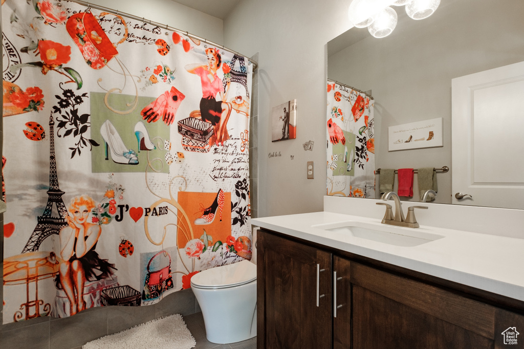 Bathroom featuring vanity, toilet, and a shower with shower curtain