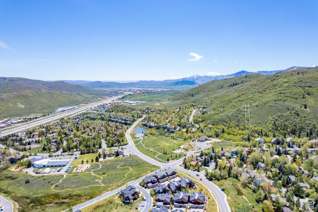 Aerial view of property and surrounding area featuring a mountain backdrop