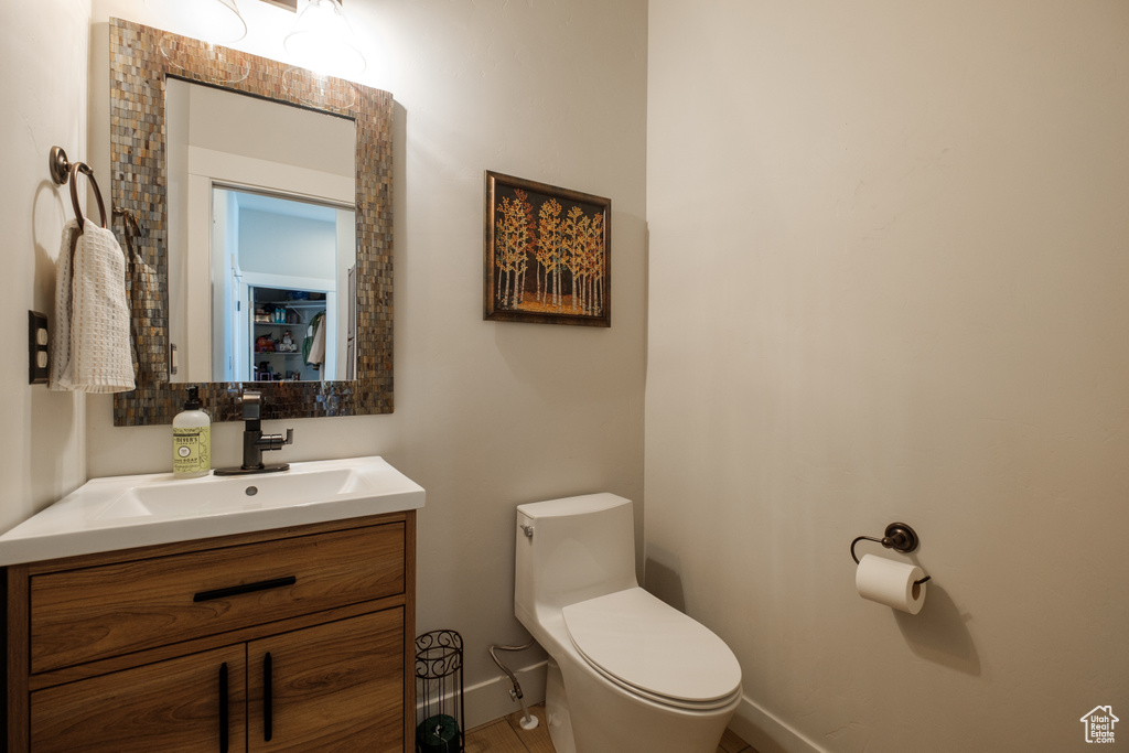 Half bath featuring vanity, toilet, and baseboards