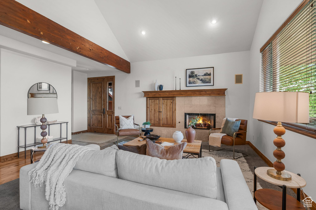 Living room featuring vaulted ceiling, a tile fireplace, recessed lighting, and wood finished floors
