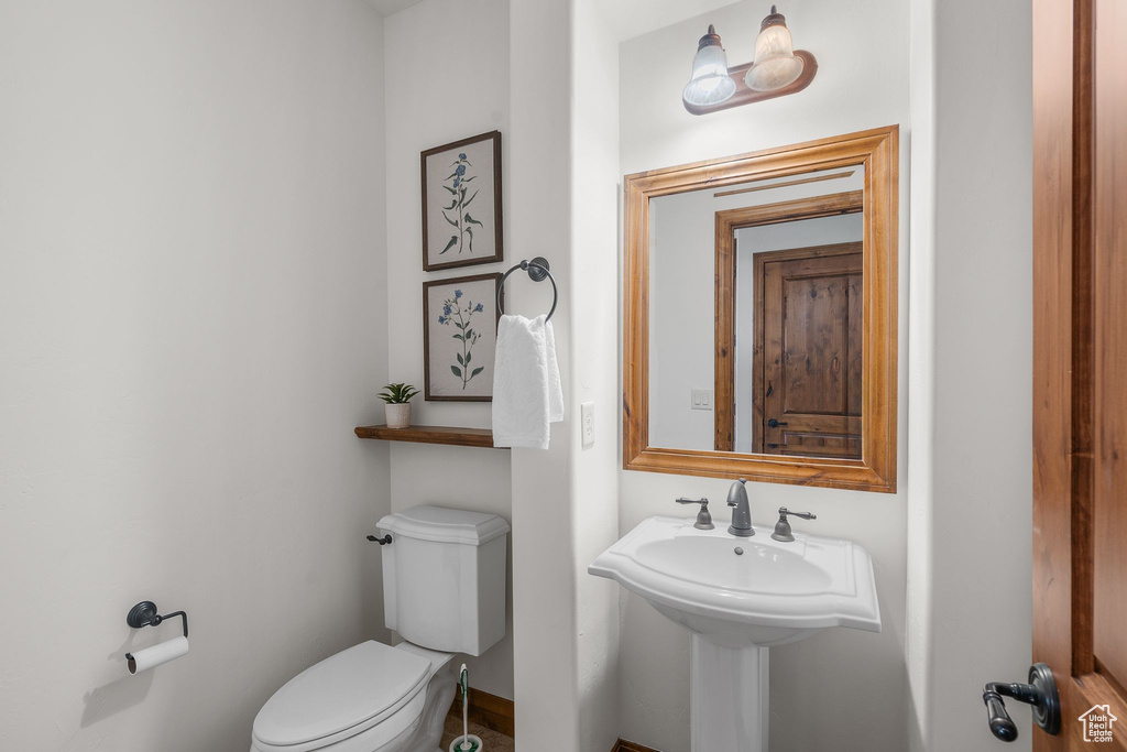 Half bath with toilet and baseboards