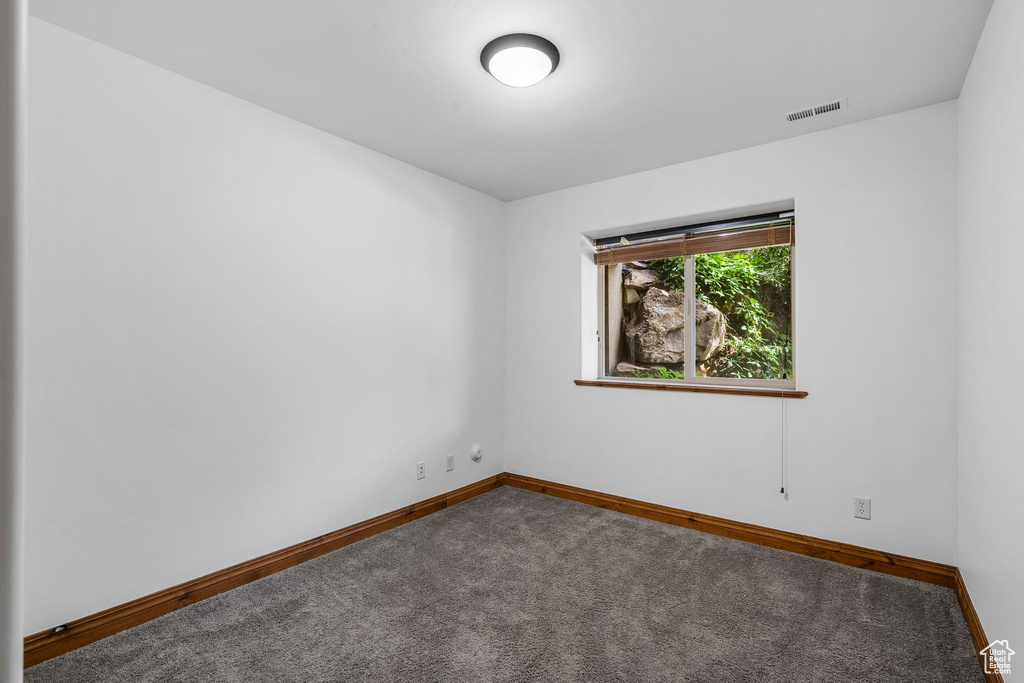 Unfurnished room featuring carpet and baseboards
