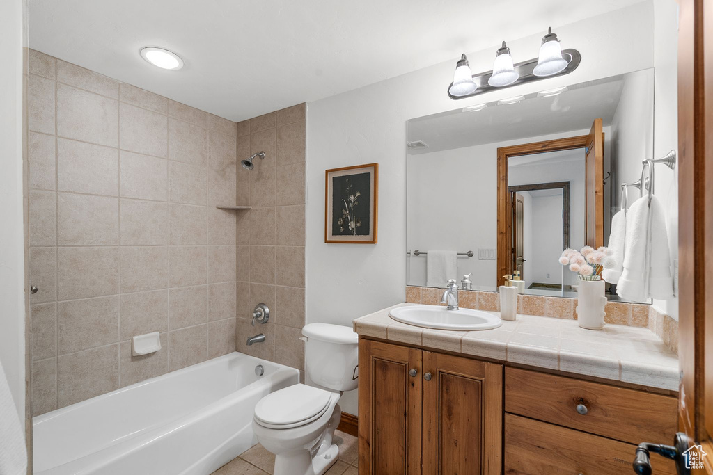 Bathroom with vanity, tile patterned floors, and bathtub / shower combination