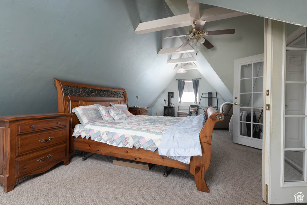 Bedroom with light colored carpet, lofted ceiling with beams, and a ceiling fan