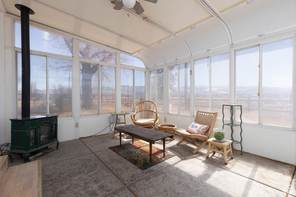 Sunroom with ceiling fan and a wood stove