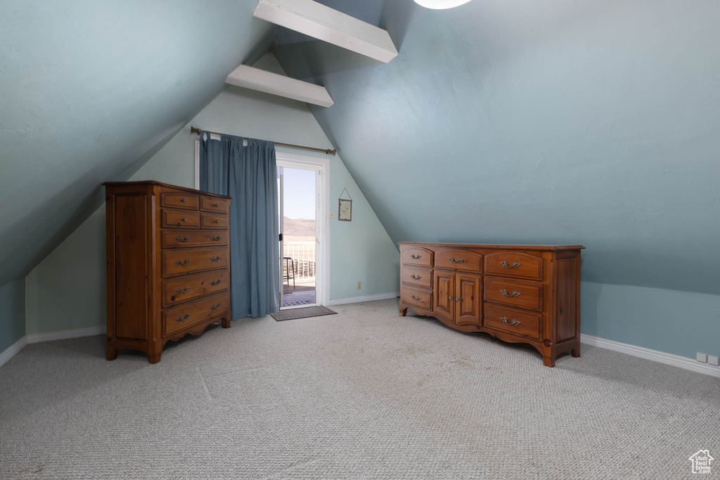 Additional living space with light colored carpet, baseboards, and vaulted ceiling