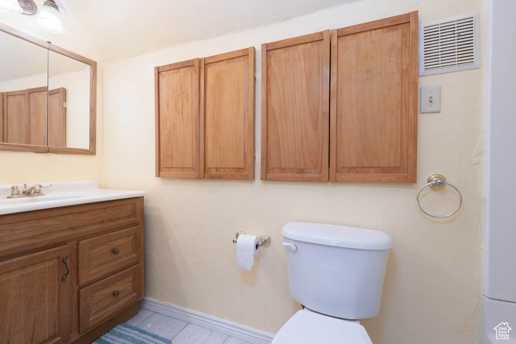 Bathroom featuring vanity, tile patterned floors, toilet, and visible vents