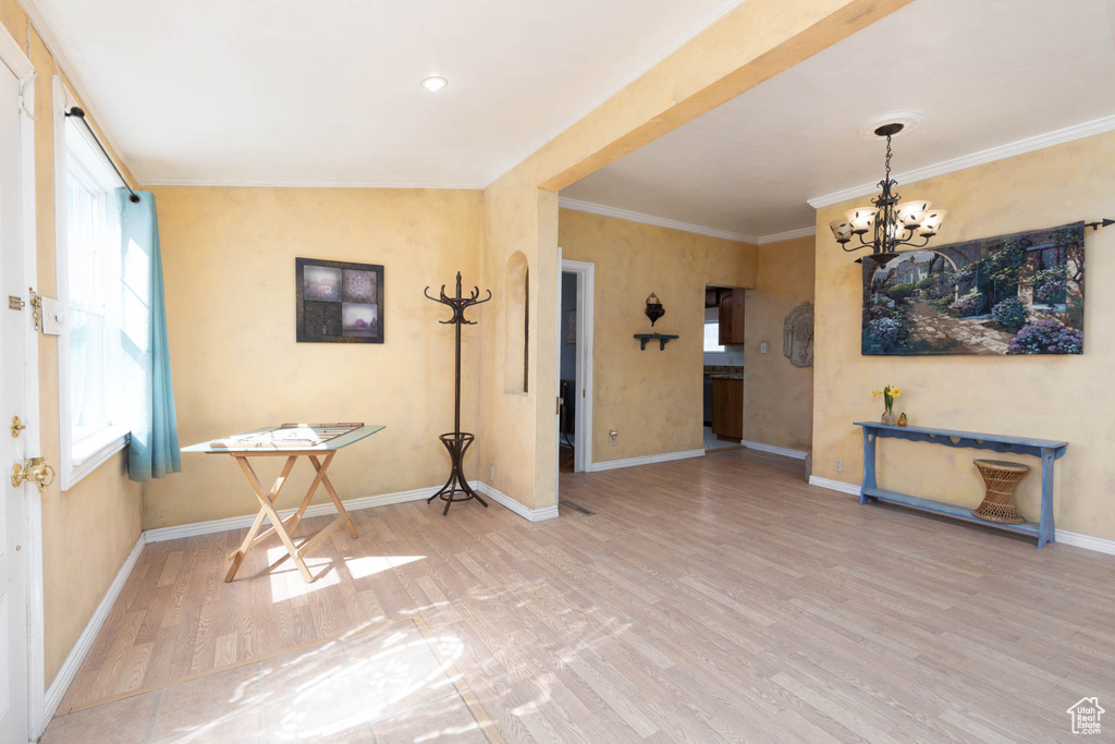 Dining area with a notable chandelier, ornamental molding, baseboards, and wood finished floors