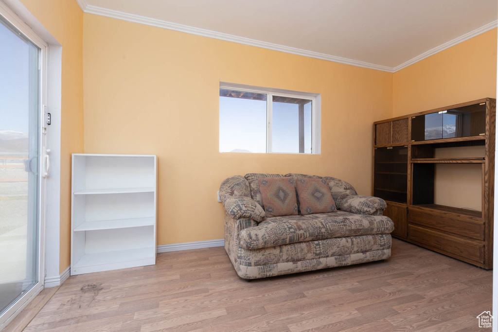 Living area featuring crown molding, baseboards, and wood finished floors