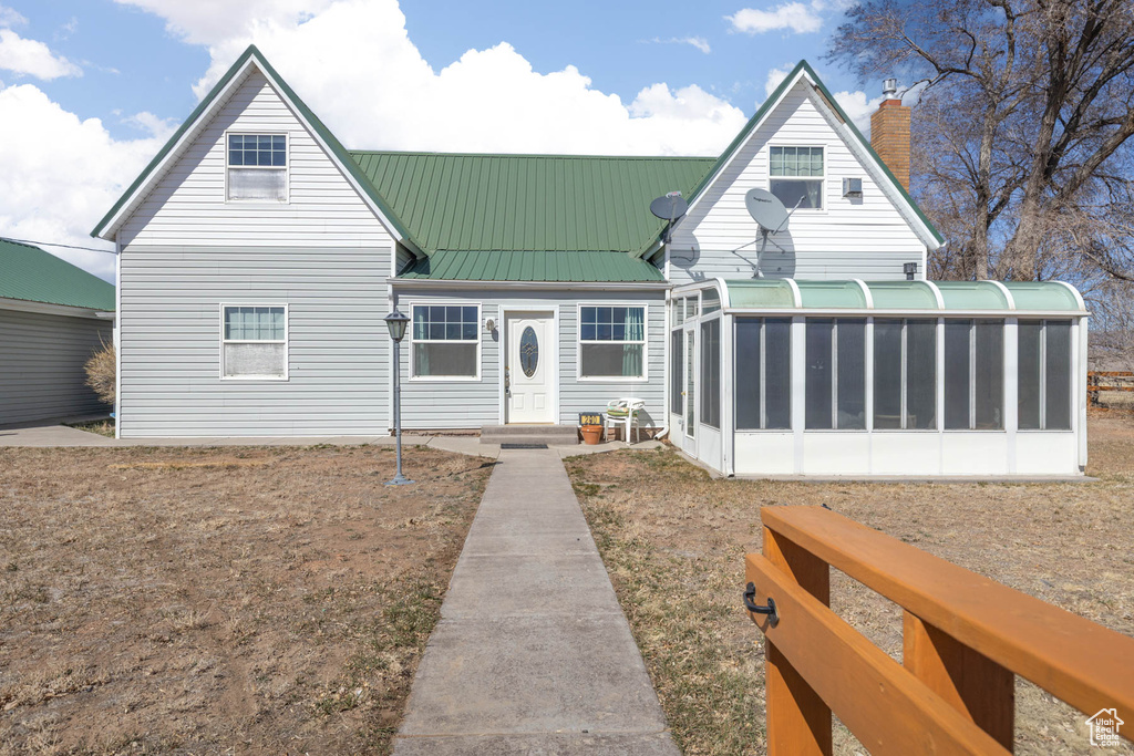 View of front of property with a sunroom and metal roof