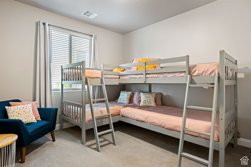 Bedroom featuring carpet flooring, baseboards, and visible vents