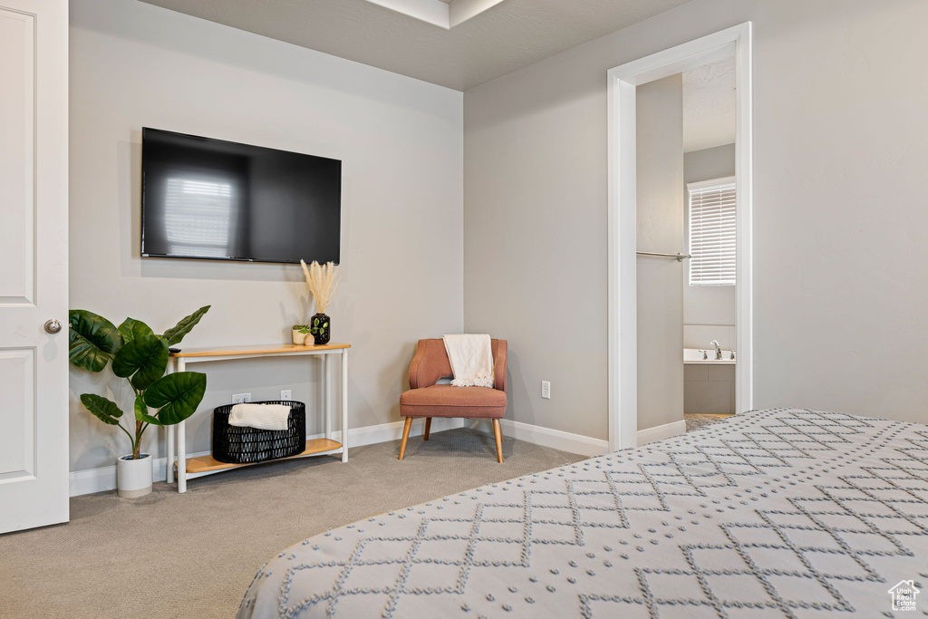 Carpeted bedroom featuring connected bathroom and baseboards