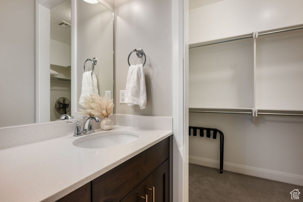Bathroom with visible vents, baseboards, and vanity