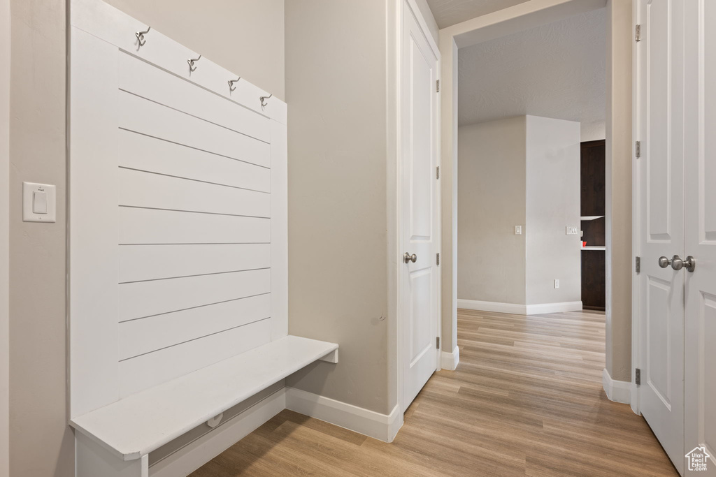 Mudroom with light wood finished floors and baseboards