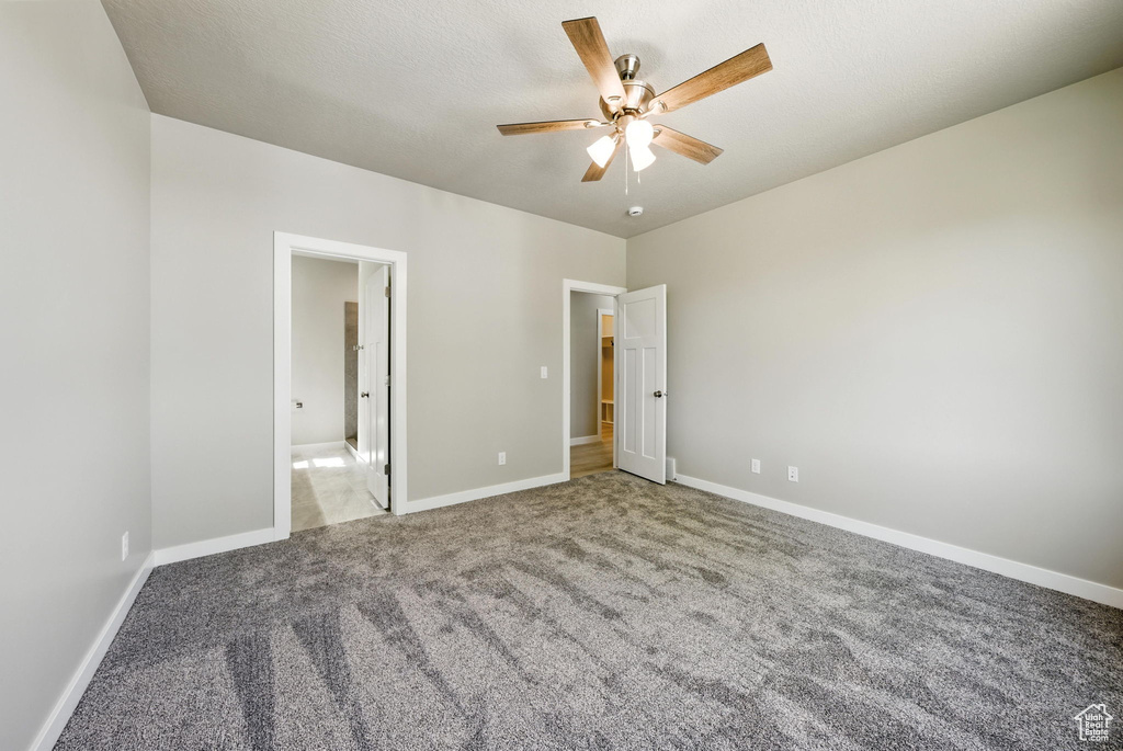Unfurnished bedroom with carpet flooring, a ceiling fan, and ensuite bath
