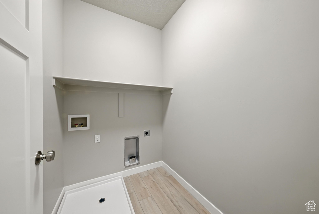 Laundry area featuring hookup for a washing machine, light wood-style floors, and hookup for an electric dryer