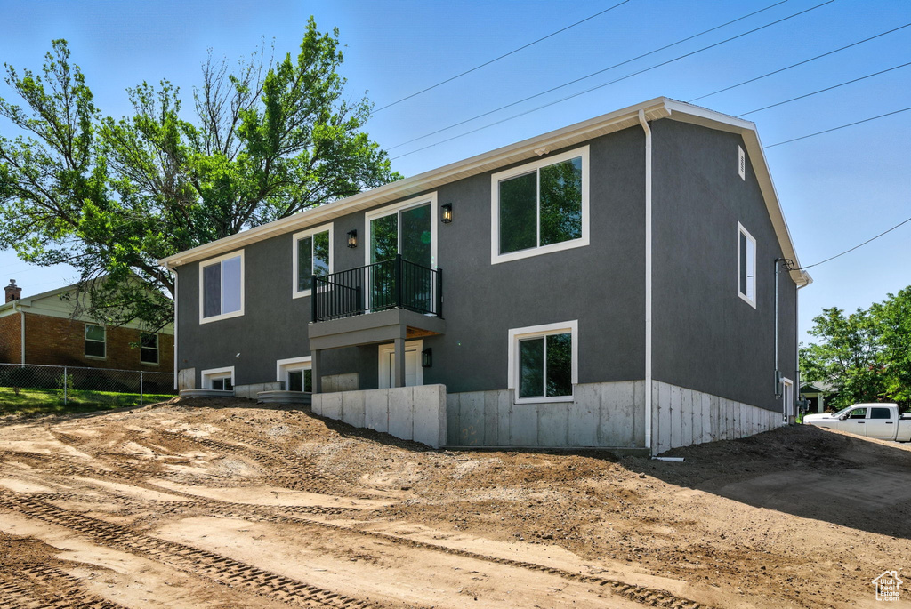 View of front of house with a balcony and stucco siding