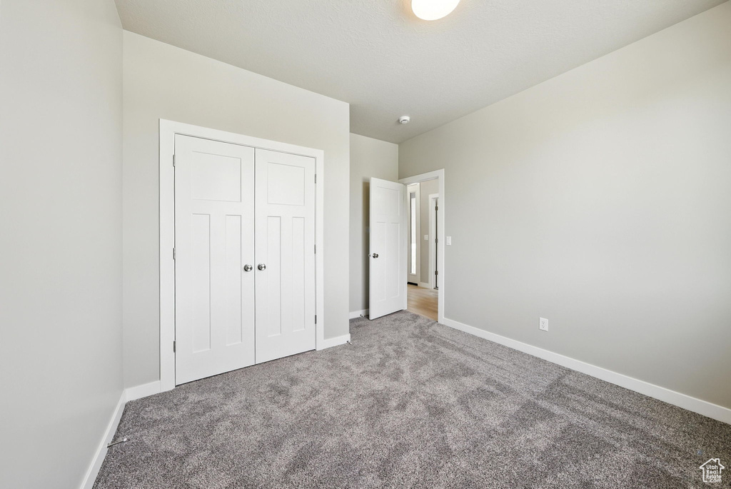 Unfurnished bedroom with carpet flooring and a closet