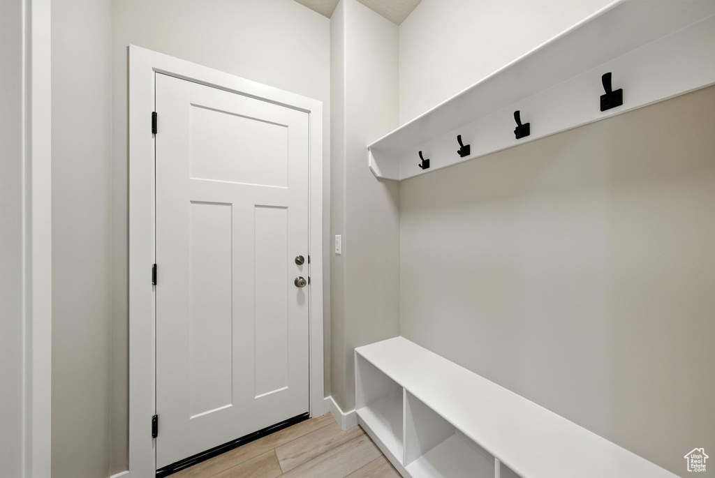 Mudroom featuring light wood finished floors and baseboards