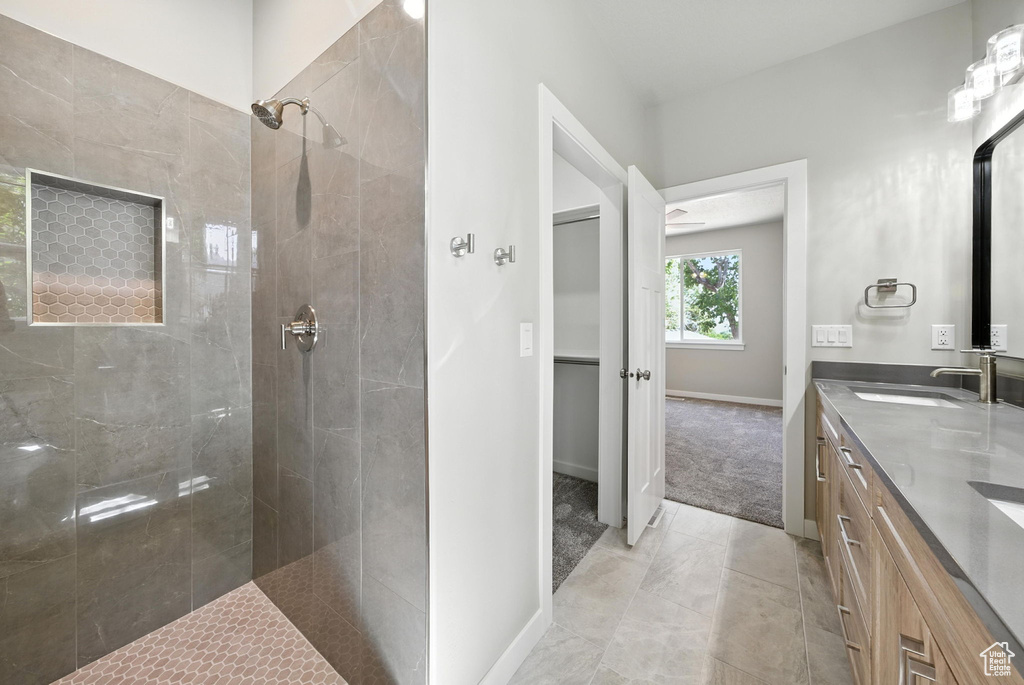 Bathroom with tiled shower and double vanity